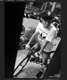 林俊杰骑单车戴帽子耳机造型帅酷
