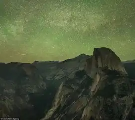 男子凌空坐在世界边缘观赏浩瀚星空俯瞰绝世美景
