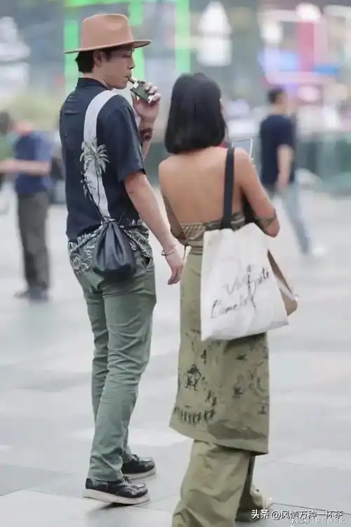 四川成都,一光脚的女子和一成熟稳重的男子手牵手走过热闹的街头